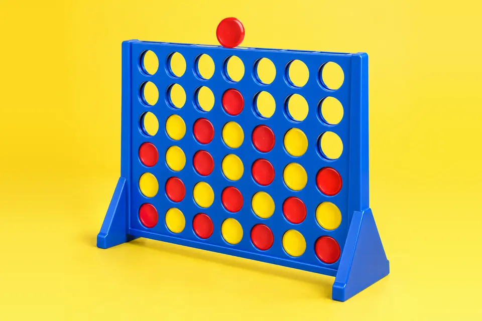 A blue four-in-a-row frame with red and yellow discs, yellow backdrop